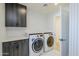 Well-organized laundry room with modern machines, cabinets, and stylish patterned wallpaper at 8525 E Vía De Los Libros --, Scottsdale, AZ 85258