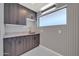 A well-appointed laundry room with custom cabinets, countertop, stylish wallpaper and sink at 8525 E Vía De Los Libros --, Scottsdale, AZ 85258