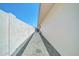 An exterior walkway on the side of the home lined with modern gravel and block fence offers privacy and curb appeal at 8525 E Vía De Los Libros --, Scottsdale, AZ 85258
