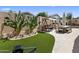 This backyard has a cozy lounge swing, dining area, desert landscaping and a beautiful travertine patio at 8934 E Calle Buena Vis, Scottsdale, AZ 85255