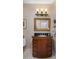 Bathroom with wooden vanity, black countertop, framed mirror, and decorative light fixture at 8934 E Calle Buena Vis, Scottsdale, AZ 85255