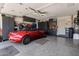 This garage features a sleek epoxy floor and custom cabinets for ample storage, along with a red convertible car at 8934 E Calle Buena Vis, Scottsdale, AZ 85255