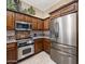 Modern kitchen with stainless steel appliances, granite countertops, and custom wood cabinets at 8934 E Calle Buena Vis, Scottsdale, AZ 85255