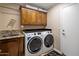 Laundry room with front-load washer and dryer, and built in cabinet storage at 8934 E Calle Buena Vis, Scottsdale, AZ 85255