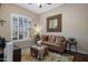 Cozy living room featuring a decorative mirror, ottoman, and plantation shutters at 8934 E Calle Buena Vis, Scottsdale, AZ 85255
