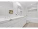 Modern bathroom featuring double sinks, quartz countertop, and a glass-enclosed shower at 9477 E Rosemonte Dr, Scottsdale, AZ 85255