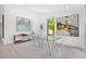 Bright dining area with a glass table, modern art, and clear acrylic chairs at 9477 E Rosemonte Dr, Scottsdale, AZ 85255