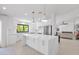 Beautiful white kitchen with a marble island, stainless steel appliances, and modern lighting at 9477 E Rosemonte Dr, Scottsdale, AZ 85255