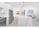 Modern kitchen with stainless appliances, a large island, and an open layout leading to dining area at 9477 E Rosemonte Dr, Scottsdale, AZ 85255