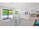 Bright, modern kitchen featuring an island, dining area, and sliding glass doors to a pool at 9477 E Rosemonte Dr, Scottsdale, AZ 85255