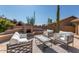 Cozy outdoor patio featuring a fireplace and comfortable seating, ideal for relaxing and entertaining at 9477 E Rosemonte Dr, Scottsdale, AZ 85255