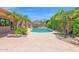 Lush backyard with a sparkling pool, desert landscaping, and an outdoor grill area at 9477 E Rosemonte Dr, Scottsdale, AZ 85255