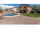 Resort style backyard with sparkling blue pool, covered patio, and low maintenance gravel at 10440 E Osage Ave, Mesa, AZ 85212