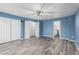 Bedroom with ceiling fan, wood-look flooring, with entrances to a bathroom and hallway at 10440 E Osage Ave, Mesa, AZ 85212