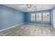Bright bedroom with a ceiling fan, wood-look flooring, and natural light from multiple windows at 10440 E Osage Ave, Mesa, AZ 85212