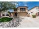 Two-story home with a two-car garage, desert landscaping, and tan exterior paint at 10440 E Osage Ave, Mesa, AZ 85212