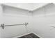 A functional walk-in closet with chrome bars, shelf, and dark plank flooring at 10440 E Osage Ave, Mesa, AZ 85212