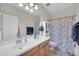 A simple bathroom with a double sink, wooden cabinets, and a shower with a marble curtain at 10613 E Knowles Ave, Mesa, AZ 85209