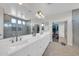 Bright bathroom featuring double sinks, a large mirror, and a glass shower with a walk-in closet at 10613 E Knowles Ave, Mesa, AZ 85209