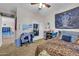 Cozy bedroom featuring neutral carpet, a black and white tapestry, and a study area, creating a personalized space at 10613 E Knowles Ave, Mesa, AZ 85209