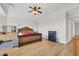 Spacious bedroom with wood floors, ceiling fan, and an ornate wooden bed frame at 10613 E Knowles Ave, Mesa, AZ 85209