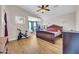 Spacious bedroom with hardwood floors, a seating area, and a large wood bed frame with a red pillow at 10613 E Knowles Ave, Mesa, AZ 85209
