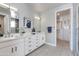 Bathroom featuring dual sinks, white countertops and cabinetry, and open access to the walk-in closet at 1111 E Missouri Ave # 9, Phoenix, AZ 85014