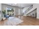 Open concept living room featuring hardwood floors, natural light, staircase, and access to outdoor patio at 1111 E Missouri Ave # 9, Phoenix, AZ 85014