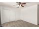 Carpeted bedroom featuring a ceiling fan and a closet with sliding doors at 11290 E Poinsettia Dr, Scottsdale, AZ 85259