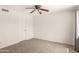 Neutral bedroom with ceiling fan, gray carpet, and white door at 11290 E Poinsettia Dr, Scottsdale, AZ 85259