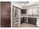 Well-lit kitchen featuring stainless steel appliances, dark cabinetry, and a tile backsplash at 11290 E Poinsettia Dr, Scottsdale, AZ 85259