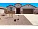 Charming single-story home features a neutral stucco facade, a brown garage door, and a low-maintenance desert landscape at 11890 E Cliffrose Ln, Florence, AZ 85132