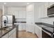 Contemporary kitchen featuring stainless steel appliances, granite countertops, white cabinets and door, and a stylish faucet at 12232 E Agave Ln, Florence, AZ 85132