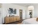 A bedroom featuring neutral-toned walls, carpet, light fixture, a wood dresser, and an abstract art piece at 12235 E Agave Ln, Florence, AZ 85132