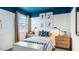 Bright bedroom with blue trim, two nightstands, striped bedding and sports themed decorations at 12247 E Agave Ln, Florence, AZ 85132
