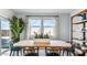 Bright dining area featuring a wooden table, blue chairs, and large windows, ideal for Gathering meals and gatherings at 12247 E Agave Ln, Florence, AZ 85132