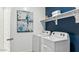 Well-equipped laundry room with modern appliances, overhead storage, and an artistic wall decoration at 12247 E Agave Ln, Florence, AZ 85132