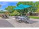 Relaxing backyard patio featuring an outdoor dining set, lounge chairs, and a pristine pool surrounded by lush greenery at 1292 N Renee Ave, Gilbert, AZ 85234