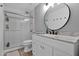 Modern bathroom featuring a walk-in shower and stylish vanity with a round mirror at 1292 N Renee Ave, Gilbert, AZ 85234