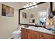 Half bath with a wood vanity, marble countertops, and decorative mirror at 1292 N Renee Ave, Gilbert, AZ 85234