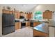 Spacious kitchen featuring oak cabinets, black appliances, granite counters, and an arch window at 1292 N Renee Ave, Gilbert, AZ 85234