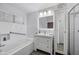 Bathroom featuring a white vanity, stylish wallpaper, and a tub with a shower at 13608 N 19Th Pl, Phoenix, AZ 85022