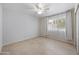 Bright bedroom with tile floors, ceiling fan, and natural light from a large window at 13608 N 19Th Pl, Phoenix, AZ 85022
