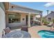 Outdoor living space featuring a covered patio, grill, pool with a spa and desert landscaping at 15753 W Kino Dr, Surprise, AZ 85374
