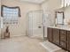 Well-lit bathroom boasts a glass shower enclosure, vanity, and a window offering natural light at 15753 W Kino Dr, Surprise, AZ 85374