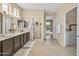 Bright bathroom featuring a double vanity, a glass shower enclosure, and a view through to the backyard at 15753 W Kino Dr, Surprise, AZ 85374