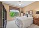 Inviting bedroom featuring a double bed, a side table and a large window that provides view of the greenery outside at 15753 W Kino Dr, Surprise, AZ 85374