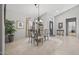 Bright dining room with a glass table, chandelier, and view of the front door entrance at 15753 W Kino Dr, Surprise, AZ 85374