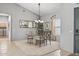 Elegant dining room with glass table, chandelier, and large mirror reflecting natural light at 15753 W Kino Dr, Surprise, AZ 85374