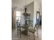 Dining area with a glass table, four chairs, decorative chandelier, and modern blue door at 15753 W Kino Dr, Surprise, AZ 85374